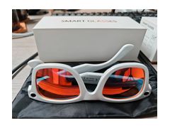 Gafas inteligentes blancas con lentes rojos sobre su caja, foto real